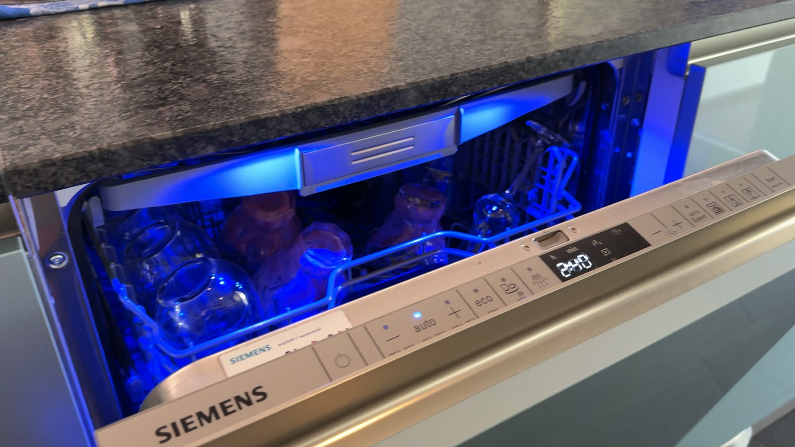 Die Siemens-Spülmaschine mit geöffneter Tür, blau beleuchtetem Innenraum und Bedienblende
